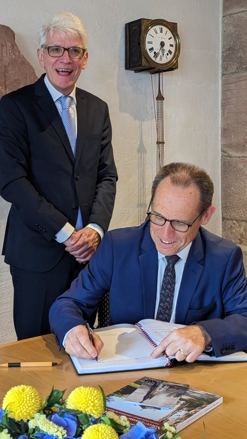 Bürgermeister Klaus Hoffmann freut sich darüber, dass Claude Bebon, Bürgermeister der elsässischen Gemeinde Dauendorf-Neubourg, sich in das Goldene Buch der Stadt Bad Herrenalb einträgt. 