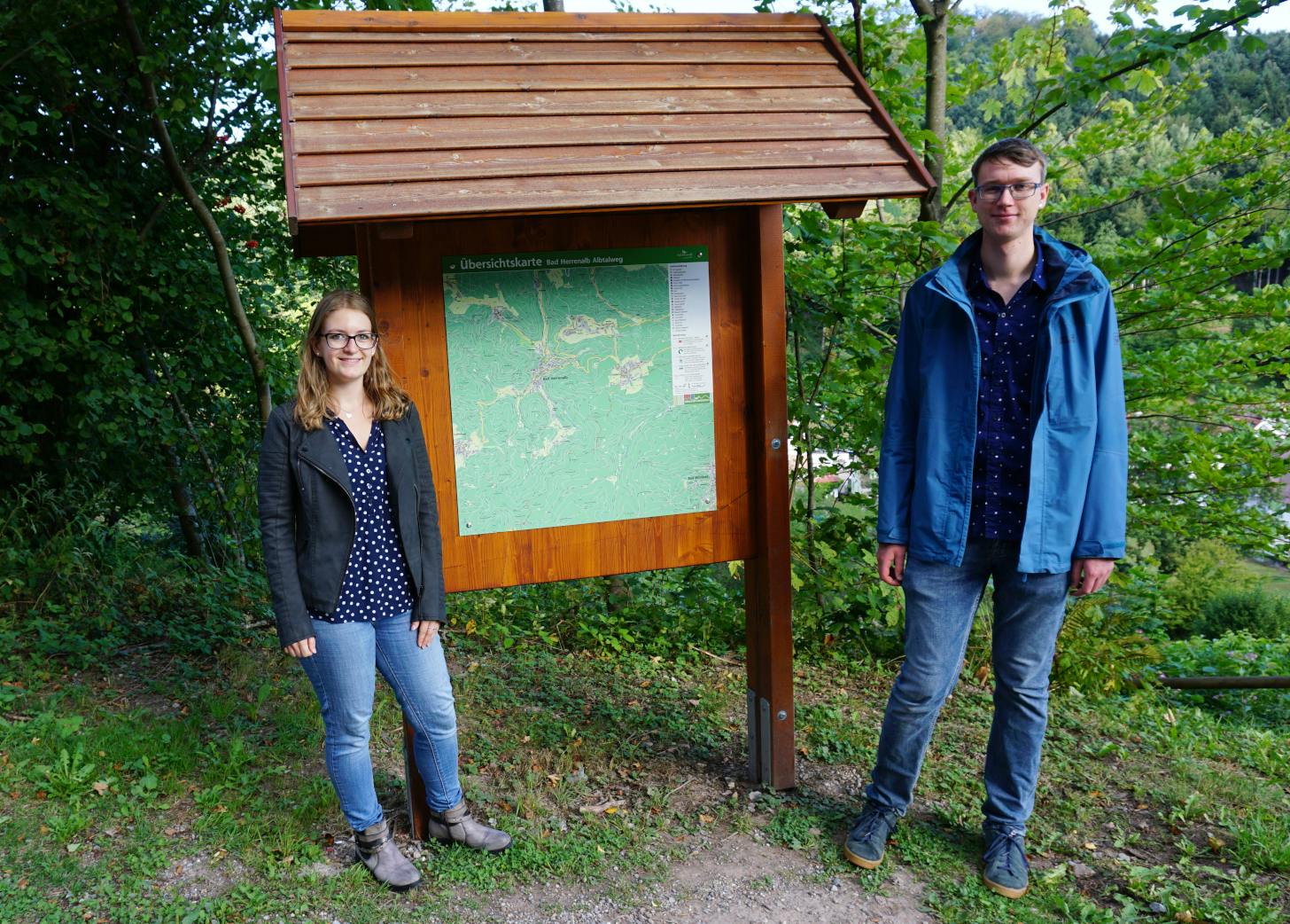 Rick Eichner, der die Übersichtskarten ehrenamtlich neu erstellt hat und Julia Riegger von Touristik Bad Herrenalb präsentieren die sanierte Wandertafel am Albtalweg. ©Stadt Bad Herrenalb